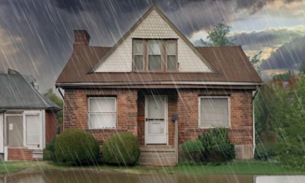 Bungalow suburbano con patio inundado bajo una fuerte tormenta