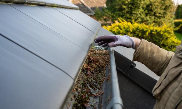A person cleaning their gutters
