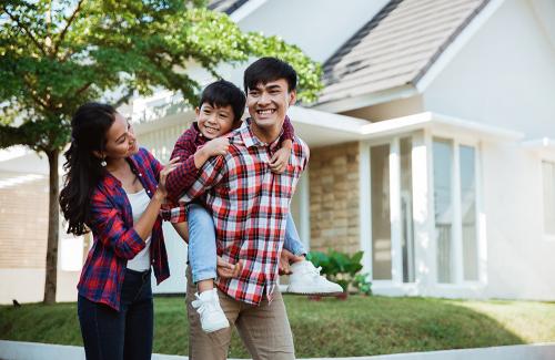 Familia feliz frente a un hogar