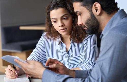 Man and woman sitting down reading documents
