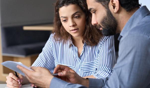 Man and woman sitting down reading documents