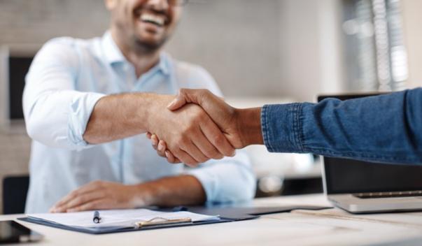 Man shaking another person's hand in office