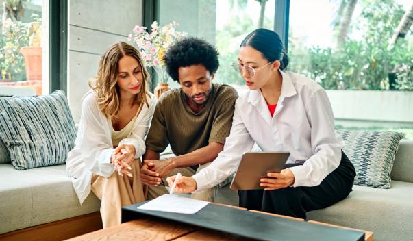 Three people in room going over documents